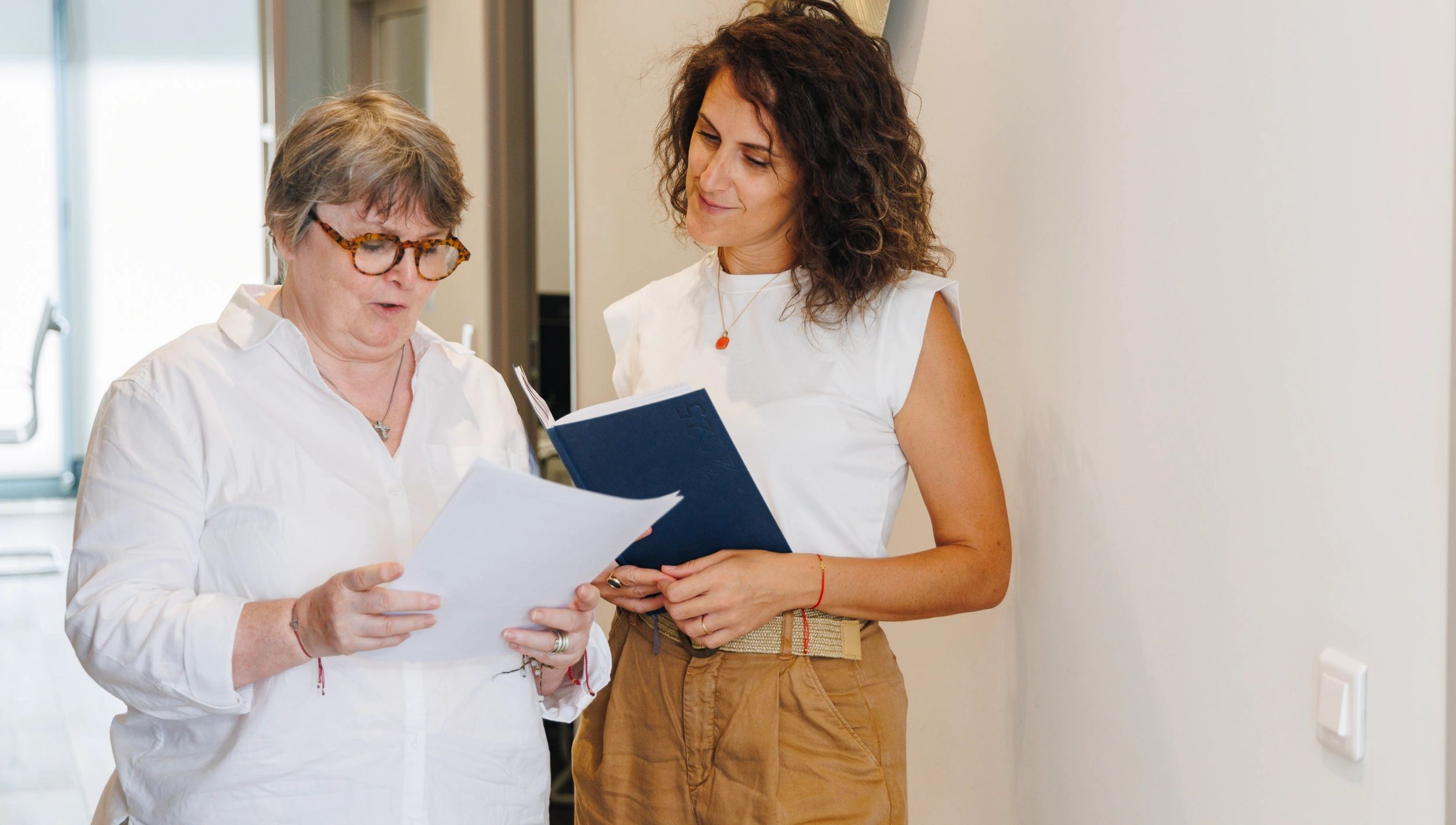 Conseillère immobilière présentant un document à une cliente dans un intérieur 