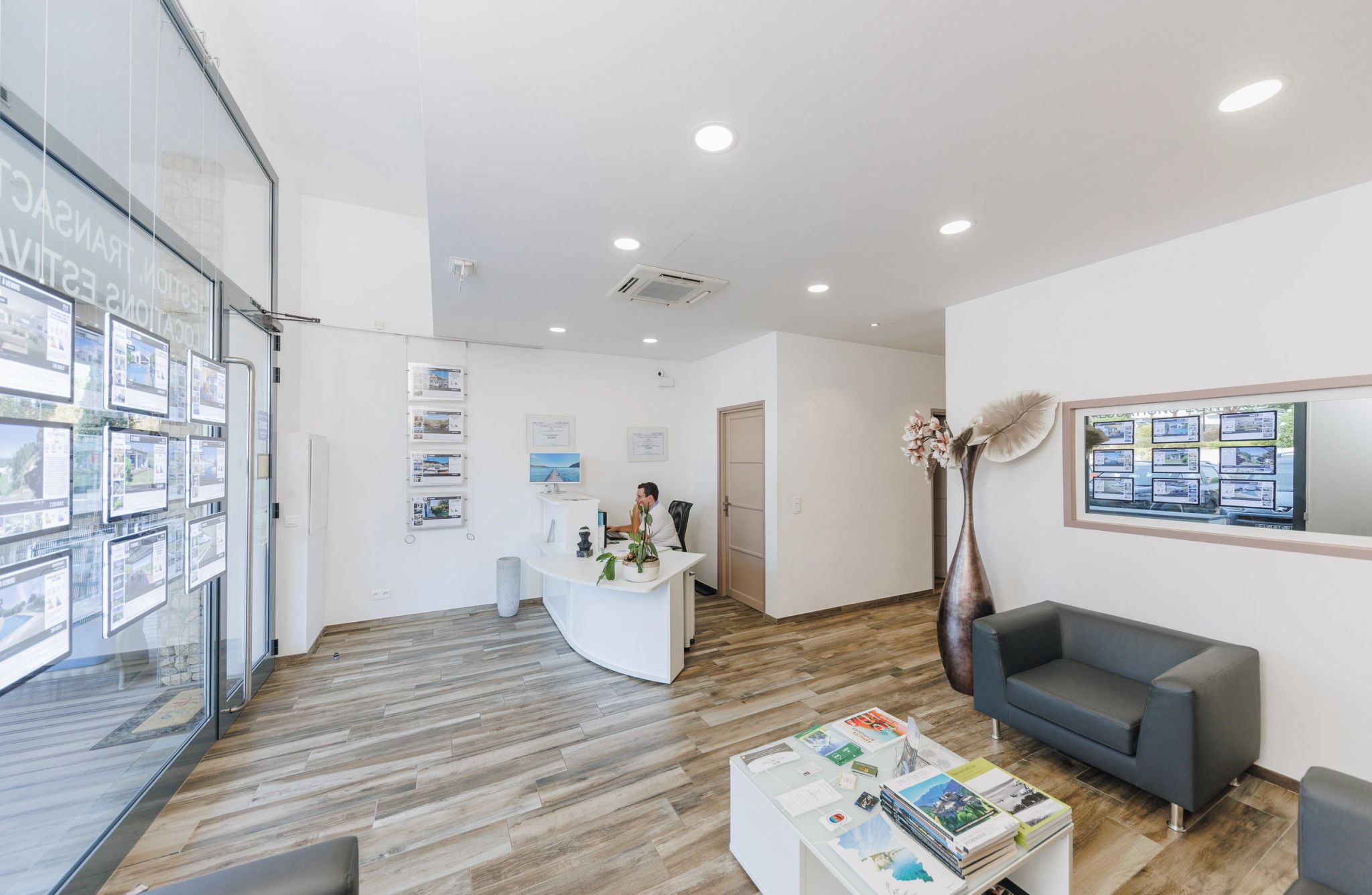 Espace d’accueil de l’agence immobilière GTI avec présentoirs, canapés et décoration moderne