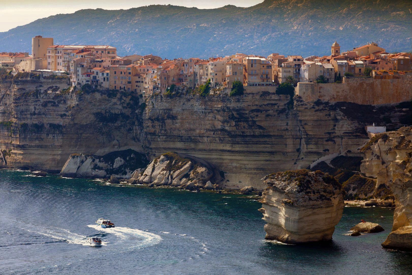 Falaises de Bonifacio surplombant la mer avec un bateau à proximité 
