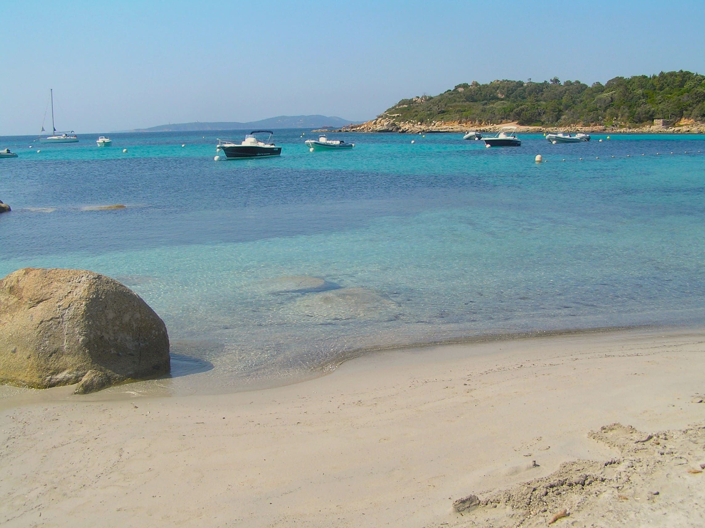Plage de sable clair avec eau turquoise et rochers dans le sud de la Corse