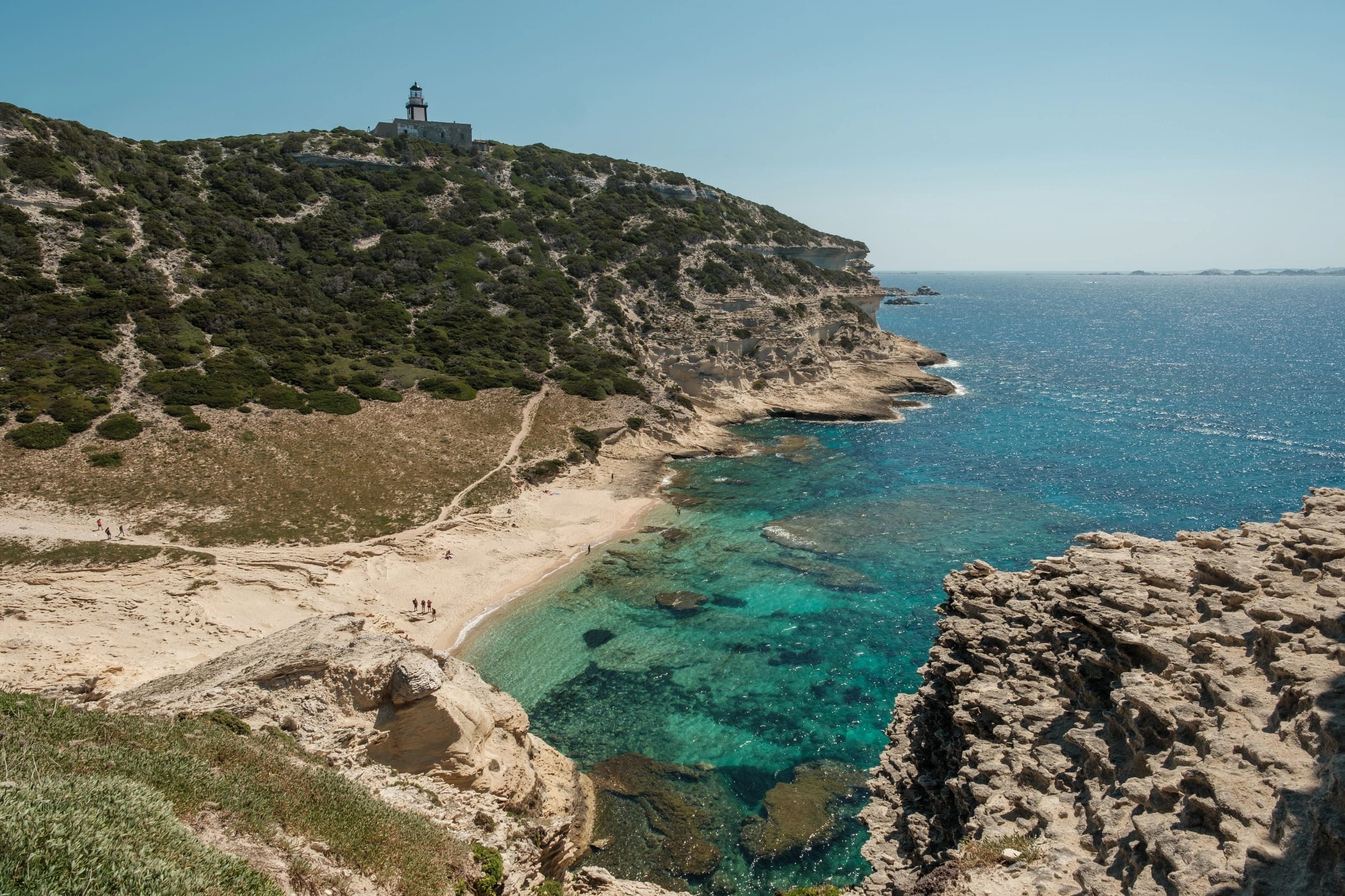 Côte rocheuse et sentier surplombant une mer turquoise en Corse du Sud