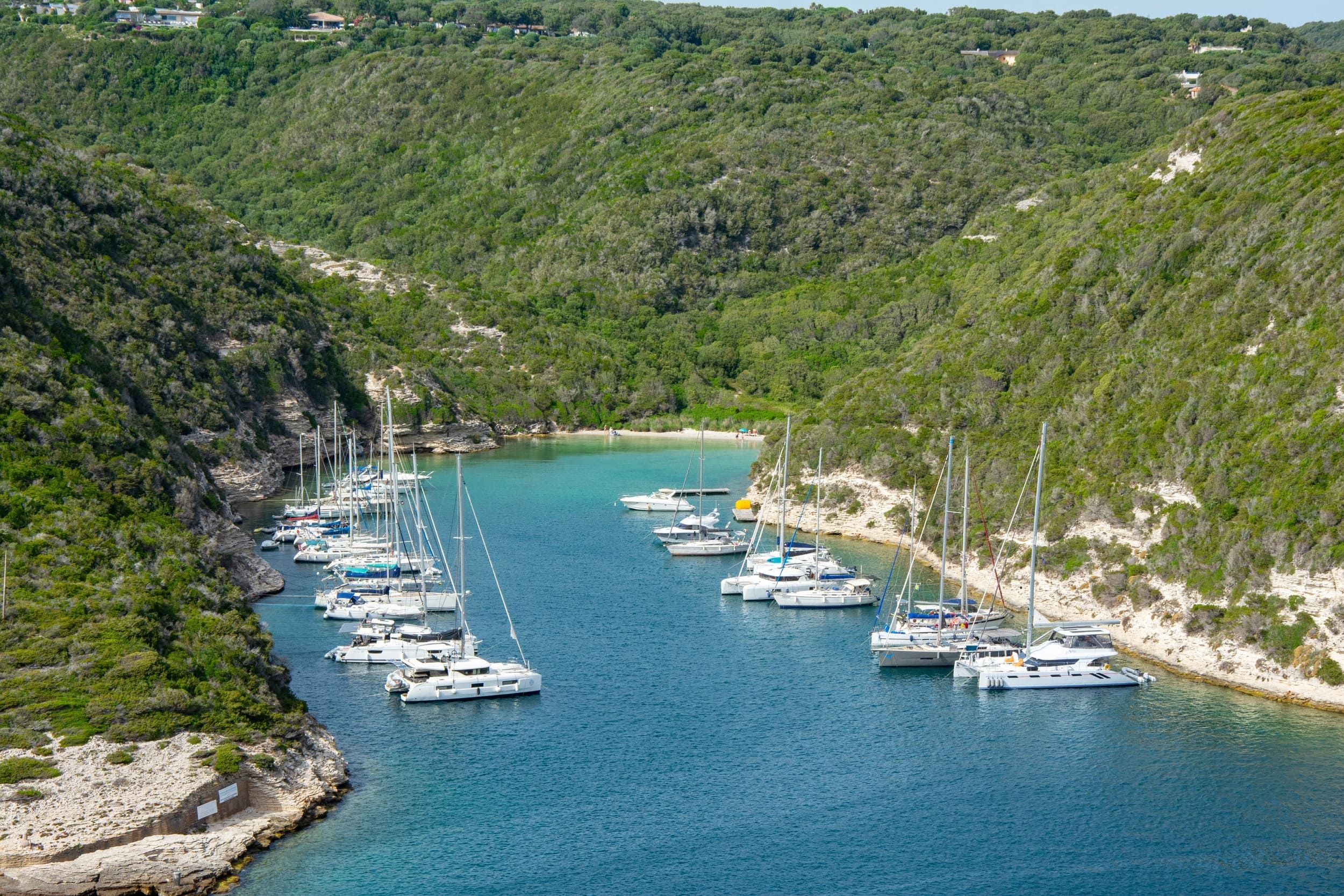 Baie bordée de collines avec voiliers au mouillage dans le sud de la Corse